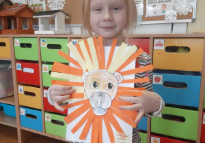 Martynka prezentuje swoją pracę plastyczną- portret lwa.